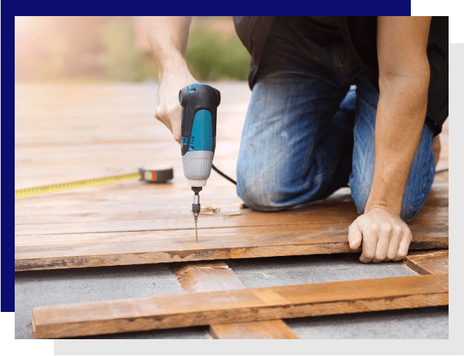 A man using a drill to build a deck.