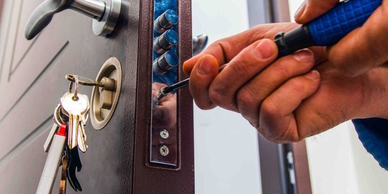 A person is locking up the door of a house.